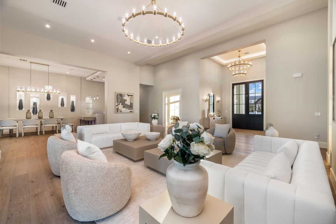 Great room with white sofas, two chandeliers and steel-framed doors